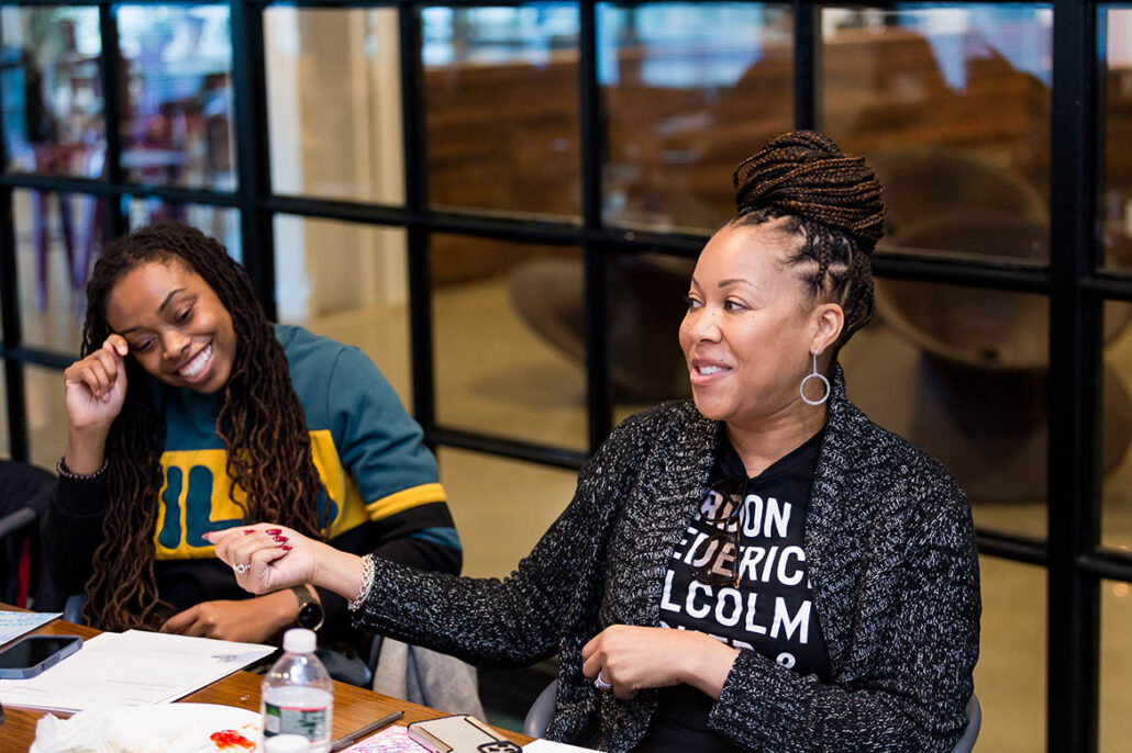 Philadelphia Surge Academy cohort - two female cohort members sitting at a table and smiling
